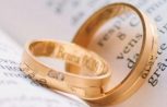 Close-up of wedding rings resting on the pages of an open book, symbolizing love and commitment.